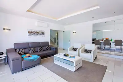 a living room with a couch and two chairs and a table at Villa Sandra by Villa Plus in Olhos de Água