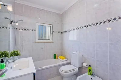a bathroom with a toilet and a sink and a tub at Villa Sandra by Villa Plus in Olhos de Água