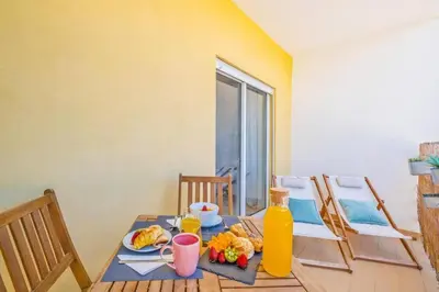 a dining room table with a plate of food and orange juice at Solymar Apartment in Guia