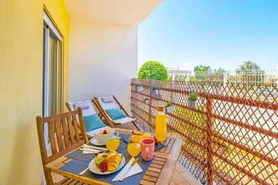a table with plates of fruit on a balcony at Solymar Apartment in Guia