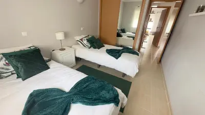 two beds in a room with a mirror at Solymar Apartment in Guia