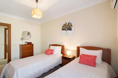 a bedroom with two beds with red pillows at Condomínio Quinta do Vale in Guia