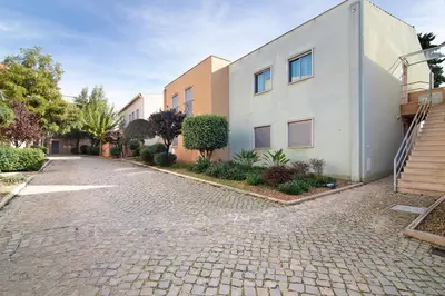a cobblestone street in front of a building at Condomínio Quinta do Vale in Guia