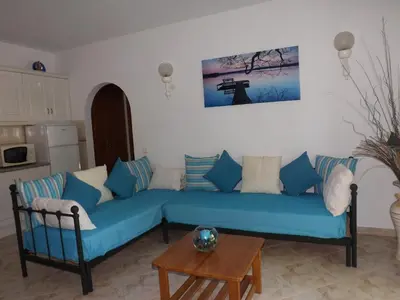 a living room with a blue couch and a table at Casa Pinheiromar in Albufeira