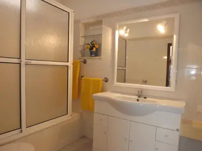 a bathroom with a sink and a shower and a mirror at Casa Pinheiromar in Albufeira