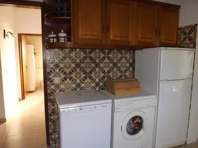 a kitchen with a washing machine and a refrigerator at Casa Pinheiromar in Albufeira
