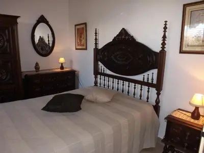a bedroom with a large bed and two dressers at Casa Pinheiromar in Albufeira