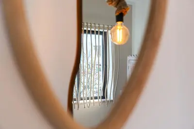 a mirror reflection of a window with a light at Gyula Old Town Apartment in Albufeira