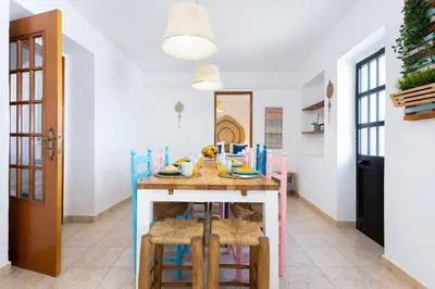 a dining room with a table with stools and a tableablish at #197 Casa Gili by Home Holidays in Albufeira