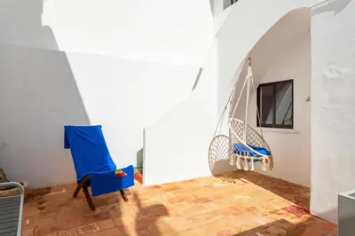 a room with blue chairs and a tv on a wall at #197 Casa Gili by Home Holidays in Albufeira