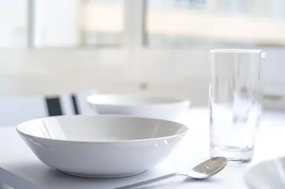 a white bowl and a glass on a table at Blife Farensya private rooms near train station in Faro