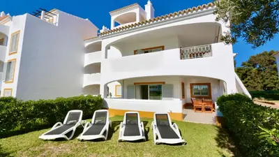 a group of lounge chairs in front of a house at Green Valley 05, Cleverdetails, Sleeps 6 adults and 2 children, 4 salted water pools in Vilamoura
