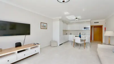 a living room with a large tv and a kitchen at Green Valley 05, Cleverdetails, Sleeps 6 adults and 2 children, 4 salted water pools in Vilamoura