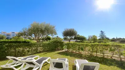 a group of lawn chairs sitting in the grass at Green Valley 05, Cleverdetails, Sleeps 6 adults and 2 children, 4 salted water pools in Vilamoura