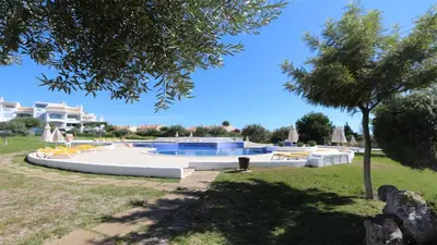 a swimming pool in a park with a tree at Green Valley 05, Cleverdetails, Sleeps 6 adults and 2 children, 4 salted water pools in Vilamoura