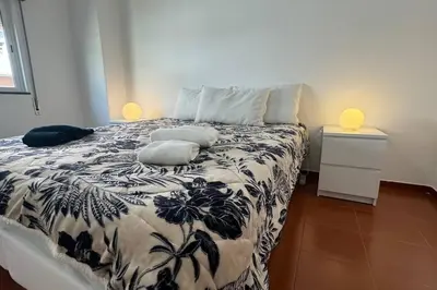 a bedroom with a bed with a black and white comforter at XperienceHouse Algarve in Quarteira