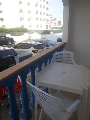 a table and chairs and cars parked in a parking lot at STUDIO COMPLETO PARA 2 PESSOAS in Albufeira
