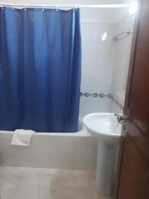 a bathroom with a blue shower curtain and a sink at STUDIO COMPLETO PARA 2 PESSOAS in Albufeira