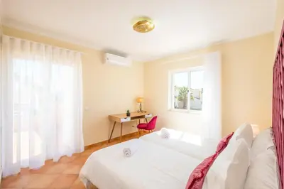 a bedroom with a bed and a desk and a window at Villa alhabu in Albufeira