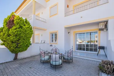 a patio with a table and chairs in front of a building at Notre Damme Apartment in Albufeira