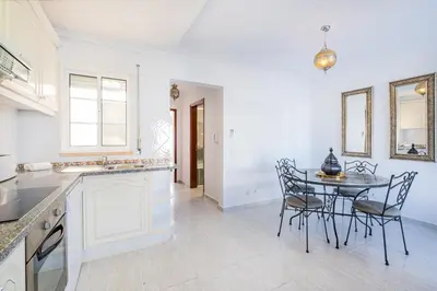a kitchen and dining room with a table and chairs at Notre Damme Apartment in Albufeira