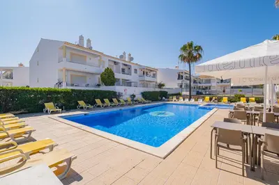 a swimming pool in front of a building at Notre Damme Apartment in Albufeira