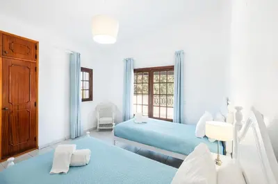 a white room with two beds and a window at Villa Guerreiro in Albufeira