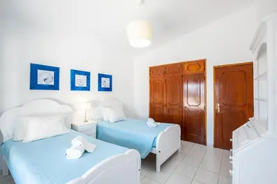 two beds in a room with white and blue at Villa Guerreiro in Albufeira