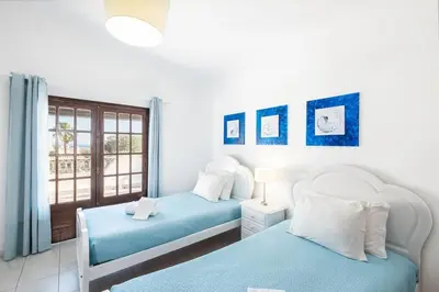 two beds in a room with a window at Villa Guerreiro in Albufeira
