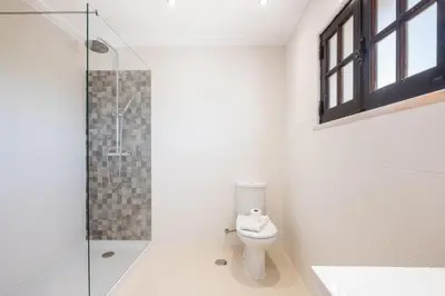 a bathroom with a toilet and a glass shower at Villa Guerreiro in Albufeira