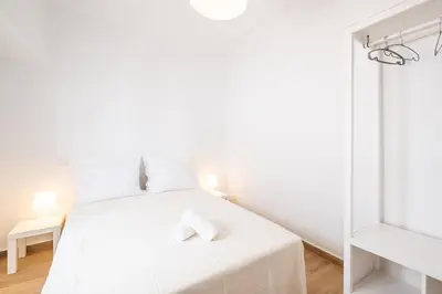 a white bedroom with a white bed with white pillows at SERAFIM BEACH APARTMENT - Heart of the Old Town in Albufeira