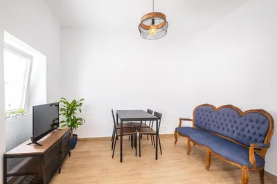 a living room with a blue couch and a table at SERAFIM BEACH APARTMENT - Heart of the Old Town in Albufeira