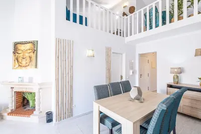 a dining room with a wooden table and blue chairs at Apartamento Casa Vela in Albufeira