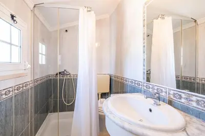 a white bathroom with a sink and a shower at Apartamento Casa Vela in Albufeira