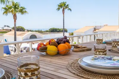 a table with a bowl of fruit on a balcony at Apartamento Casa Vela in Albufeira