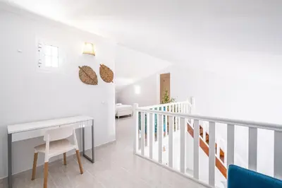 a white room with a desk and stairs at Apartamento Casa Vela in Albufeira