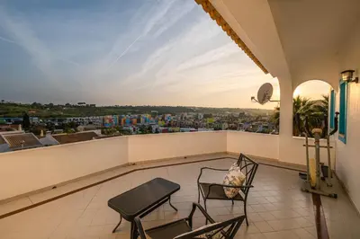 a balcony with chairs and a view of a city at Villa Melissa in Albufeira
