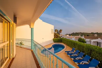 a balcony with chairs and a swimming pool at Villa Melissa in Albufeira
