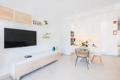 a living room with a table and a tv on a wall at Guerreiros Lovely Stay in Albufeira