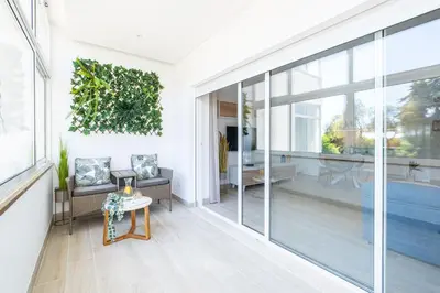 a living room with a large window and a table at Guerreiros Lovely Stay in Albufeira
