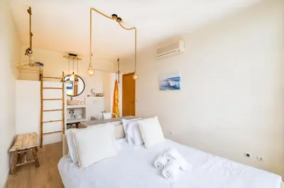 a bedroom with a white bed with white pillows at Anabella Guest House in Albufeira
