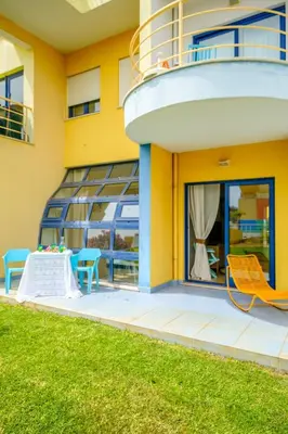 a yellow building with a balcony with chairs and a table at Anabella Guest House in Albufeira