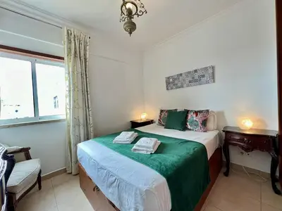a bedroom with a bed with a green blanket at Albufeira Vintage Apartment 1 With Pool by Homing in Albufeira
