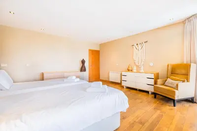 a bedroom with two beds and a chair at Casa Picota in Boliqueime