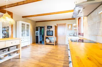 a large kitchen with wooden floors and white cabinets at Casa Picota in Boliqueime