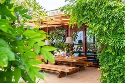 a wooden table and benches in a garden at Casa Picota in Boliqueime