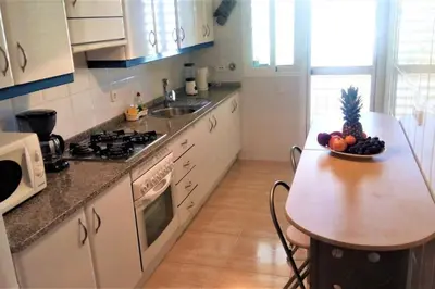 a kitchen with a table with a bowl of fruit on it at Charming 3 bed apartment @ Al-Sakia Village in Quarteira