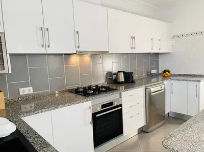 a kitchen with white cabinets and a stove top oven at Charming 5 bed Private Villa - Quarteira in Quarteira