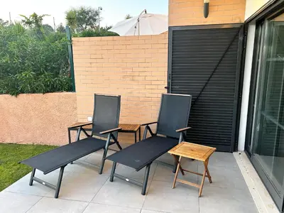 three chairs and a table on a patio at Three Bedroom Sea View Townhouse Villa in Albufeira