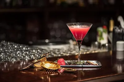a drink in a glass sitting on top of a bar at Pine Cliffs Suites in Albufeira